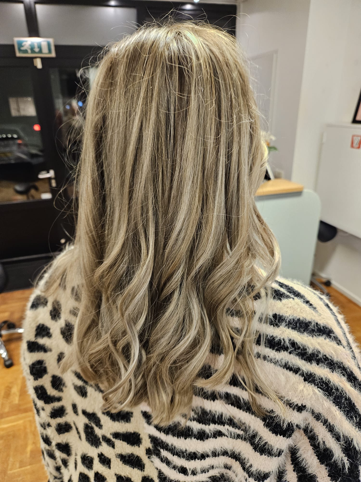 Lang haar met lichte highlights in zachte slagen, van achteren gezien